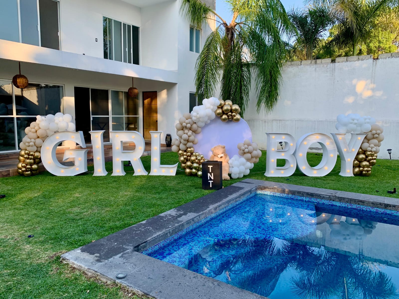 Decoración con globos blanco, dorado y beige con letras LED para revelación de género - Perfect Party