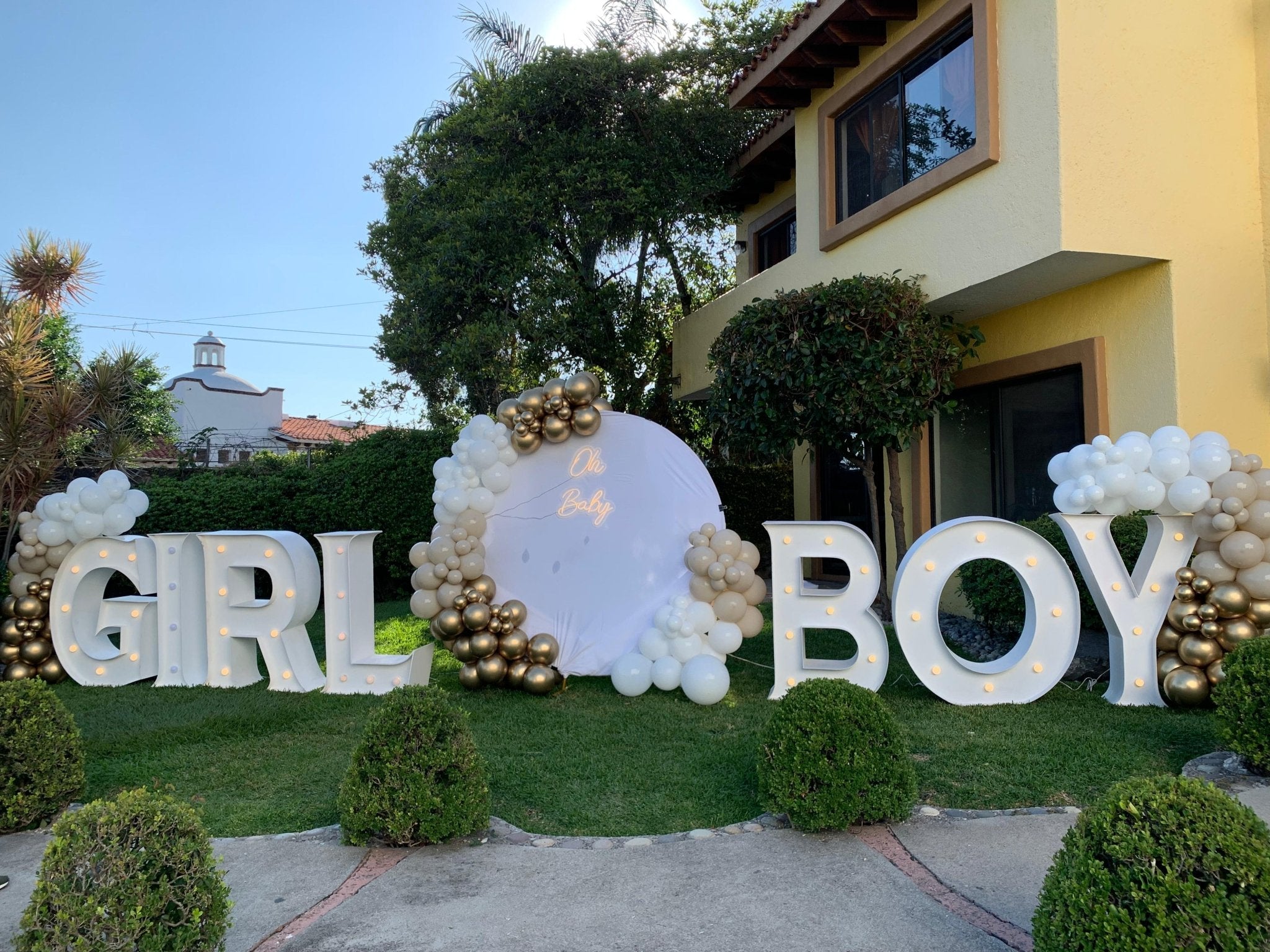 Decoracion con globos blanco, dorado y cromado con letrero Oh Baby y letras LED para revelación de género - Perfect Party