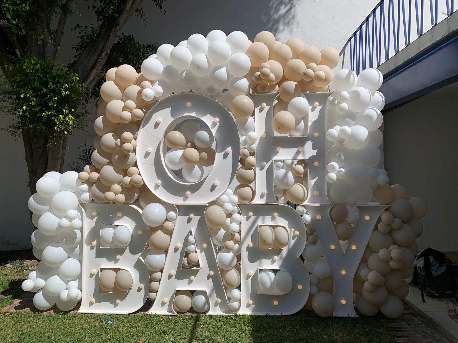 Decoracion con globos blanco y beige con letrero Oh Baby y letras LED para revelación de género - Perfect Party