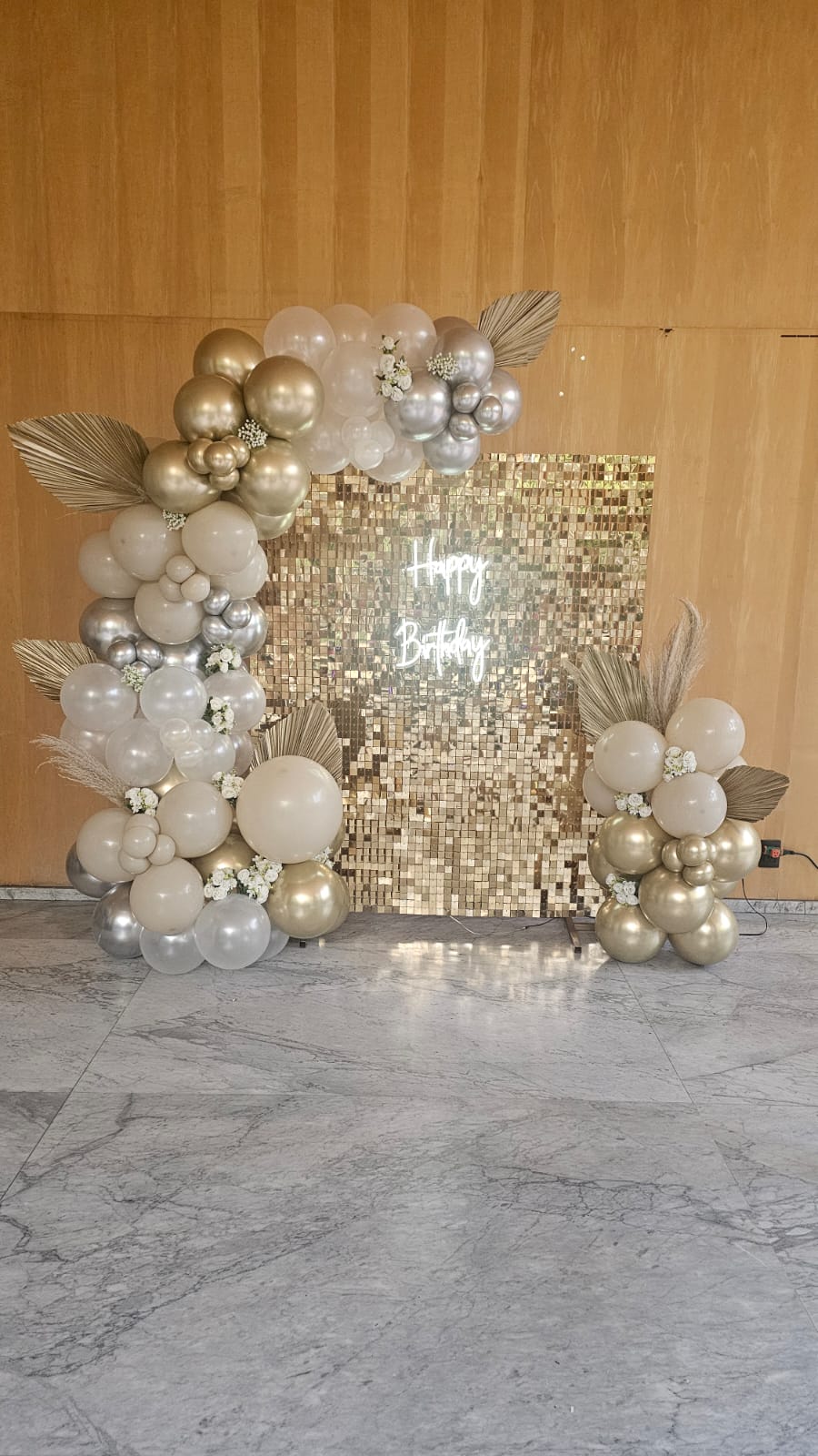 Shimmer wall en interior con mármol blanco, dorado y plateado con letrero Happy Birthday y flores para cumpleaños - Perfect Party